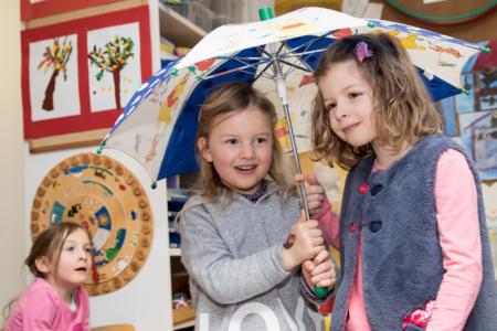 Zwei Schülerinnen unter Regenschirm